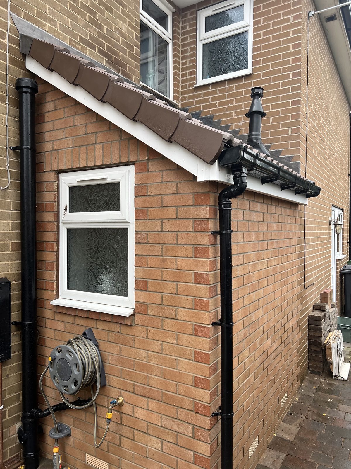 A finished brick single-storey extension with a tiled roof and new downpipes