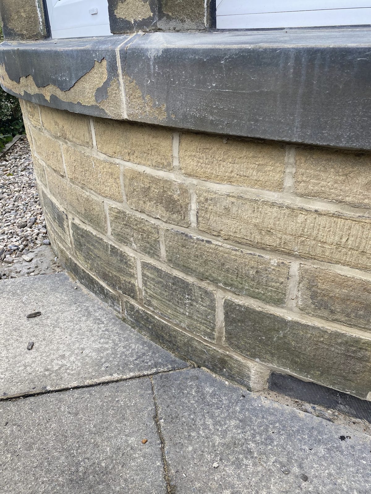 Close-up of a curved stone bay wall under a stone sill